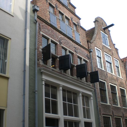 Onderkelderd huis met gepleisterde segmentvormig afgesloten klokgevel