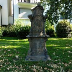 Ein zweiteiliger Bildstock aus Sandstein mit leicht nach vorn gewölbtem Postament. Inschrift auf der  Vorderseite von Konsolvoluten gerahmt. Das Bildstockrelief zeigt: Liborius links, Antonius rechts, in der Mitte das Jesuskind mit Gloriole