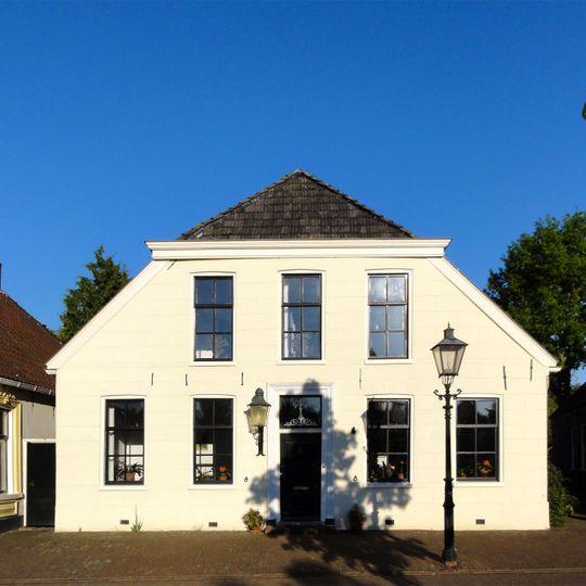 Pand onder zadeldak met wolfseind boven gepleisterde voorgevel