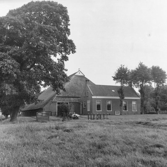 Dwarshuisboerderij onder zadeldak haaks op dat van de schuur