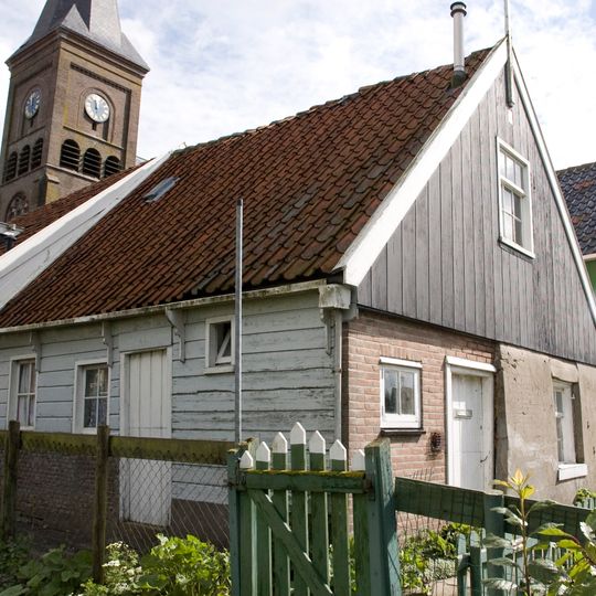 Houten huis met topgevel en daklijst op consoles