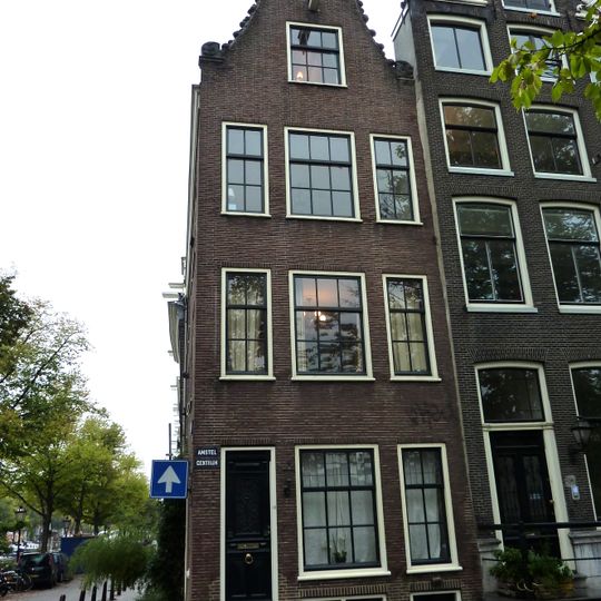 Hoekhuis aan de amstel vanwege de incomplete zandstenen afdekkingen van de klokvormige top