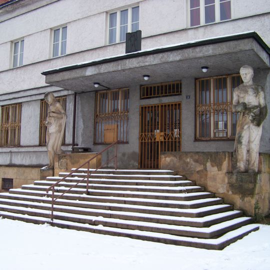 Sochy u vchodu do bývalé spořitelny v Lomnici nad Popelkou