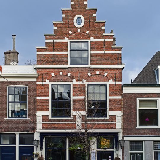 Pand met trapgevel versierd met natuurstenen banden, geprofileerde waterlijsten, geblokte ontlastingsbogen en in de top een cartouche-vormig blind oeil-de-boeuf