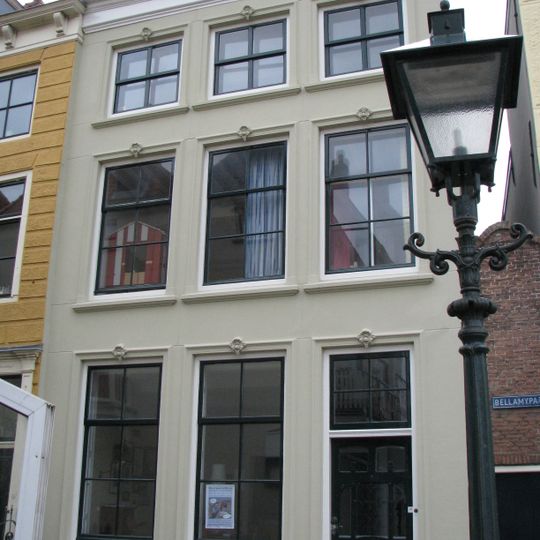 Huis met gepleisterde lijstgevel. Eenvoudige voordeuromlijsting. Dakkapel