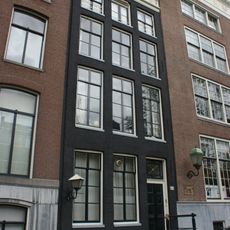 Pand met gevel onder verhoogde lijst met consoles