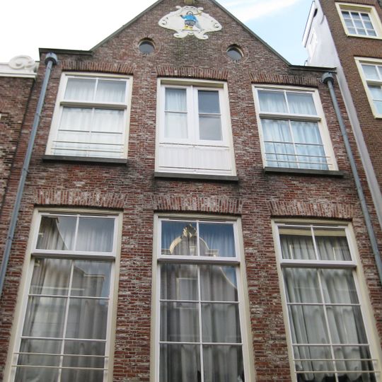 Huis voorzien van een halsgevel met gedeelde vleugelstukken en een palmet in de afdekking