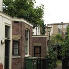 Blok van vier rug-aan-rug gebouwde woningen op vierkante plattegrond, bestaande uit begane grond en verdieping onder een plat dak