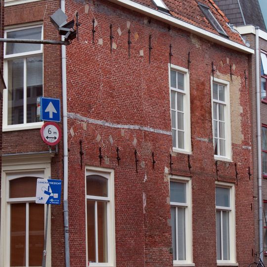 Pand met in de zijgevel aan de Minnemastraat talrijke muurankers en ontlastingsbogen