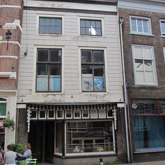 Pand met in natuursteen-imitatie gepleisterde lijstgevel