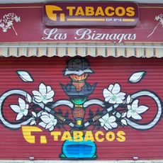 Mural en la persiana de cierre de un estanco representando una cachimba y unas flores de biznaga.