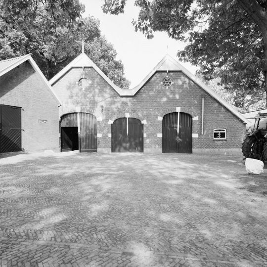 Dubbele schuur opgemetseld in rode baksteen onder een dubbel zadeldak grijze hollandse pannen