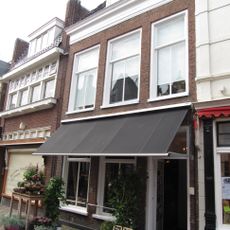 Twee bouwlagen tellend pand gedekt door een met pannen belegd schilddak