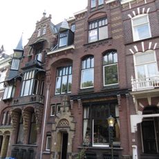 Pand in neo-renaissance trant met souterrain. Getoogde vensters. Friezen van baksteen. Boven de ingang een trapgevelbekroning.