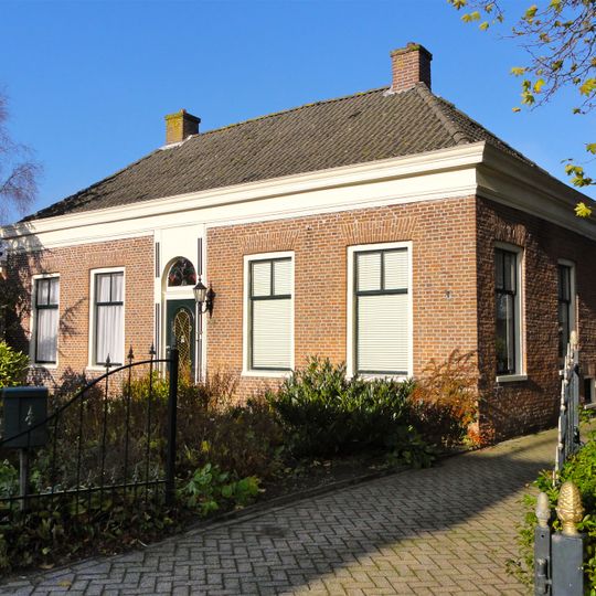 Pand onder laag schilddak met hoekschoorstenen