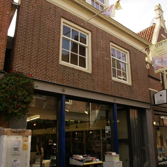 Pand onder diep zadeldak tegen oude achtergevel van puntvorm