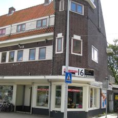 Blok met winkels met brede luifel en daarboven woningen, bouwstijl Amsterdamse School, onderdeel van het centrale achthoekige plein van Tuindorp Nieuwendam