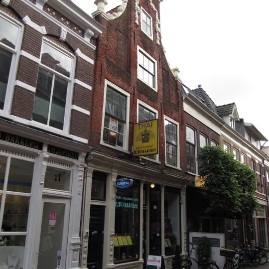 Pand met klokgevel met vooruitspringend middenstuk, versierd met guirlandes van natuursteen, ter weerszijden vazen, halfrond fronton bekroont de gevel, begin 18e eeuw verbouwd