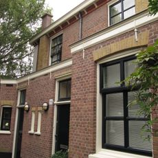 Blok van vier rug-aan-rug gebouwde woningen op vierkante plattegrond, bestaande uit begane grond en verdieping onder een plat dak