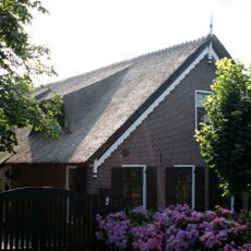 Hoeve met gave puntgevel, waarin bewerkte lijst en makelaar. Ramen uit de bouwtijd met luiken. De boerderij, die aan de achterzijde gewijzigd is, draagt een strodak