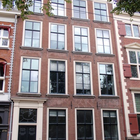 Vier verdiepingen hoog pand met kroonlijst en deuromlijsting in eenvoudige Lodewijk XVI stijl, stoephek