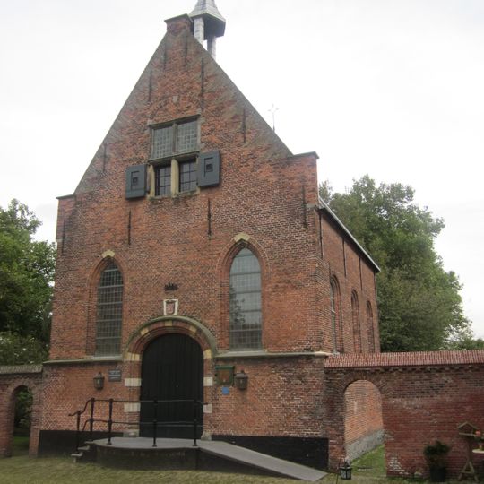 Kapel, op de muur van de kapel is een horizontale zonnewijzer ingemetseld