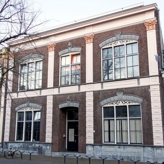 Vijf traveeën breed pand met dwarskap en eenvoudige rechte kroonlijst waarboven dakkapel