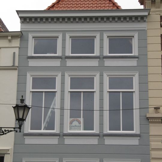 Huis met gebosseerd gepleisterde lijstgevel, lage bovenverdieping en schilddak