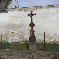 Kříž u zdi statku v Pořešíně