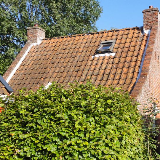 Visserswoning onder zadeldak tussen puntgevels met vlechtingen en achtruitsvensters in bepleisterde voorgevel