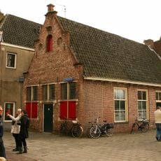 Huis met lijstgevel met gewijzigde gootlijst en pui met middendeur en zijramen
