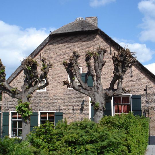 Boerderij onder een met riet gedekt wolfdak. Het woonhuis heeft een gevel met vlechtingen en vensters met zesruitsschuiframen. Zoldervenster met half-kruiskozijn en luik.