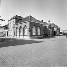 Tweezijdig aangebouwd stadhuis van één bouwlaag en een kapverdieping hoog
