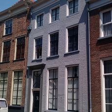 Pand met gesausde lijstgevel met deurpartij bestaande uit gesneden deur met bovenlicht en pilasters