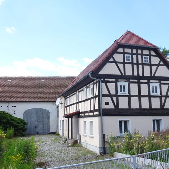 Wohnstallhaus und Stallscheune eines Gehöfts, davor Gedenkstein für Karl Traugott Schütze Hauptstraße 14