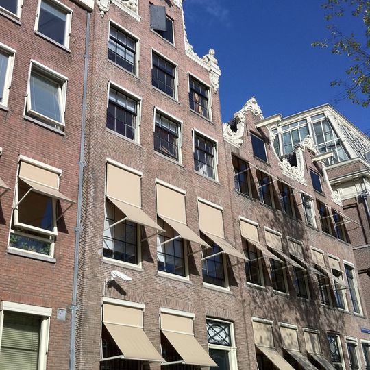 Pand met halsgevel met rijk gebeeldhouwde top van bijzonder ontwerp