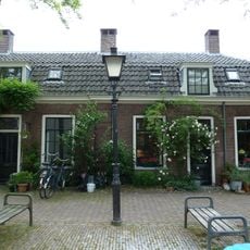 Eenlaags hoekpand onder mansardekap, op oudere kelder, vrijwoning deel uitmakend van het hofje van de Fundatie Metelerkamp