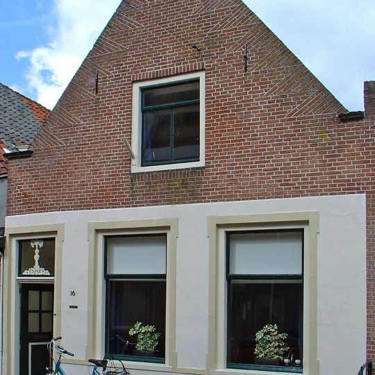 Huis met puntgevel met halfrond afgedekte top