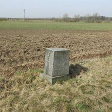 Podstavec ulomeného kříže u silnice do Rvenic