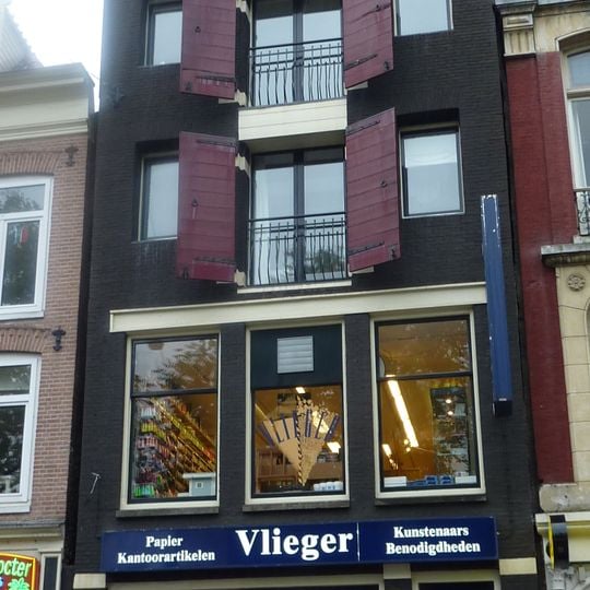 Pakhuisgevel met zware ingezwenkte hals van s-vormig silhouet voorzien van siersteentjes en een kalkoen in de volutenafdekking