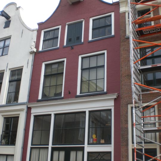 Huis met geverfde klokgevel, door rollaag en natuurstenen halfronde top afgesloten