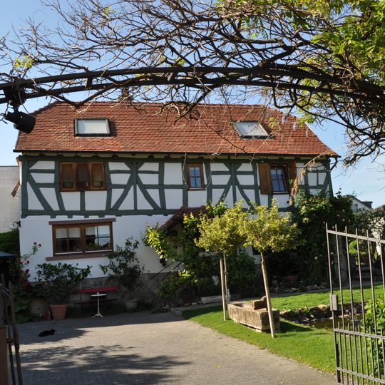 Zurückliegendes, traufständiges Wohnhaus auf Bruchsteinsockel