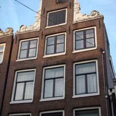 Pand met halsgevel met gedeelde vleugelstukken en palmet in de afdekking