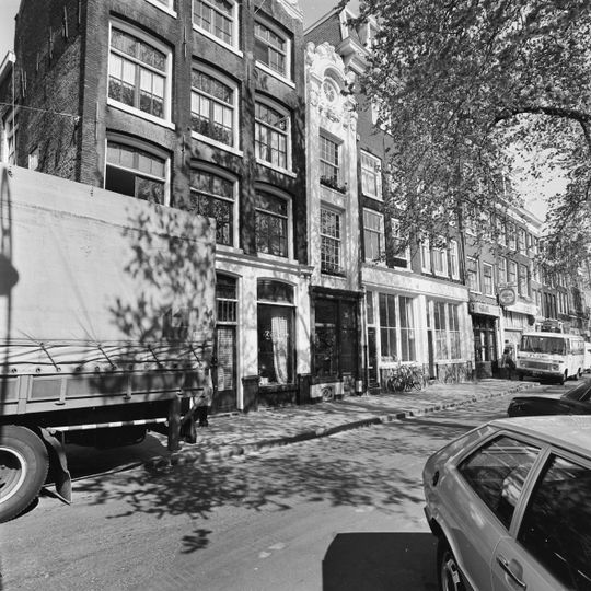 Pand met zeer smalle zandstenen lisenengevel onder gebeeldhouwde gebogen beëindiging