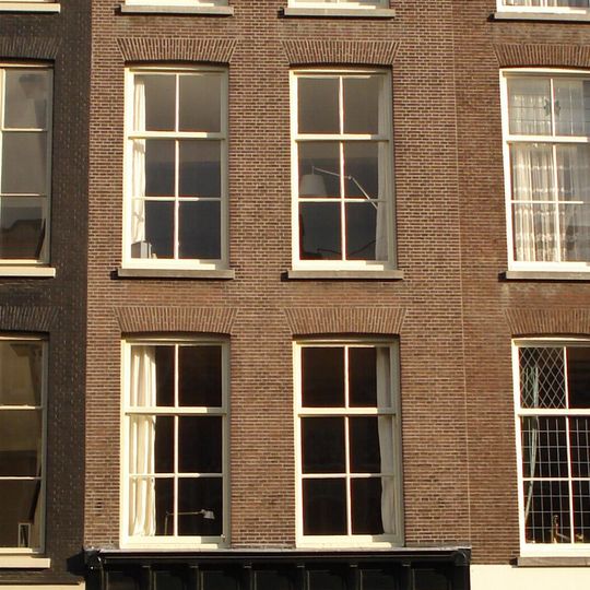 Pand met drie verdiepingen. Houten kroonlijst, rijk geprofileerd, waaronder in het fries panelen