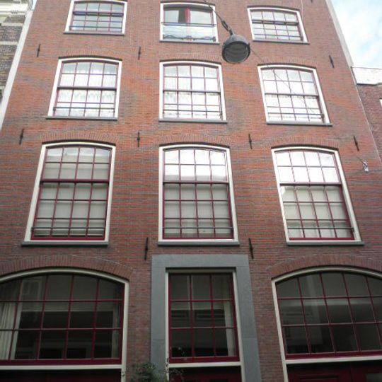 Pak- of werkhuis met tamelijk sterk getoogde vensters waarin een goede roedenverdeling