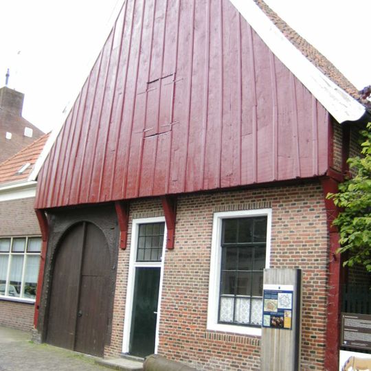Saksische hoeve met stijl- en regelwerk en hoge houten puntgevel met gesneden topmakelaar. Thans in gebruik als Grols Museum