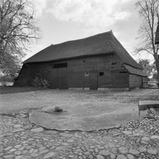 Houten bijschuur onder rietgedekt schilddak