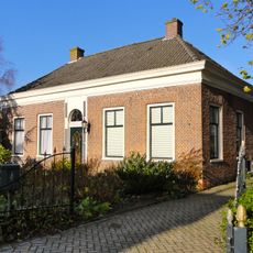 Pand onder laag schilddak met hoekschoorstenen