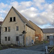 Wohnstallhaus eines Bauernhofes, dazu ein Torpfeiler der Hofzufahrt Dorfplatz 16